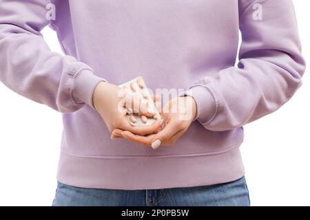 Frauenhände in Lavendel-Pullover drücken Pillen aus einer Blase. Schön gepflegte Hände und Nägel. Stockfoto