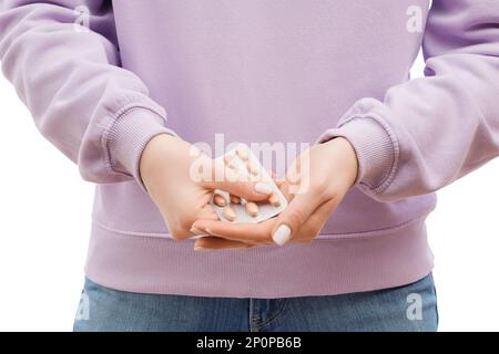 Frauenhände in Lavendel-Pullover drücken Pillen aus einer Blase. Schön gepflegte Hände und Nägel. Stockfoto