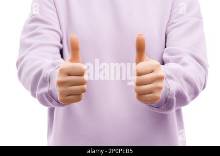 Die gekürzte Aufnahme einer Frau in einem übergroßen, lavendelfarbenen Sweatshirt zeigt zwei Daumen nach oben, wie ein Schild. Stockfoto