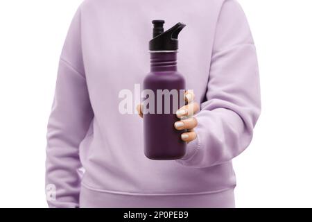 Gekürzte Aufnahme einer Frau in einem übergroßen, lavendelfarbenen Sweatshirt mit einer wiederverwendbaren violetten Edelstahlflasche. Stockfoto