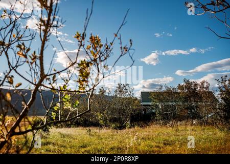 Isländische Wohnung mit blauem Himmel und flauschigen weißen Wolken über fernen Bergketten Stockfoto