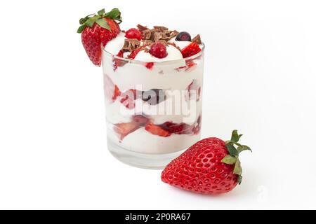 Erdbeeren, Waldfrüchte und Schlagsahne in transparentem Glas, isoliert auf weißem Hintergrund Stockfoto