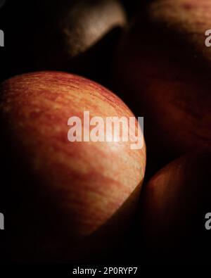 Abstraktes Foto von Apfel und anderen Früchten mit scharfem Licht- und Schattenkontrast. Makrofotografie mit selektivem Fokus. Hohe und niedrige Tasten Stockfoto