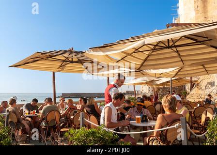 Menschen an der Waterfront Bar in Cefalu, Sizilien, Italien Stockfoto