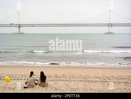 Busan, Südkorea - Mai 2019: Gwangandaegyo oder Diamond Bridge, Hängebrücke Foto vom Strand der Stadt Busan an an einem windigen Tag mit Wellen Stockfoto