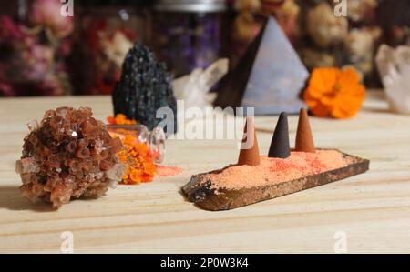 Aragonitkristall mit Weihrauch und Steinpyramide auf Meditationstisch Stockfoto