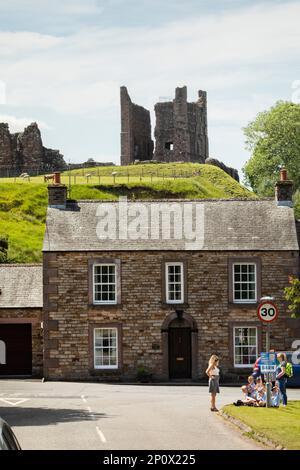 Eine Gruppe von Schulkindern und ihren Lehrern sitzen auf dem Rasen in der Nähe von Brough Castle, Cumbria Stockfoto