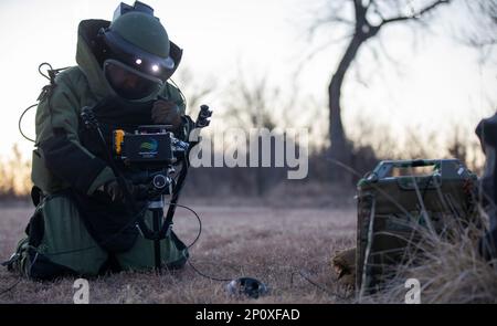 USA Army Staff Sgt. John W. Coffield, ein Spezialist für die Beseitigung von Sprengkörpern, der der 630. Ordnance Company, dem 79. EOD-Bataillon, der 71. Ordnance Group zugeteilt ist, richtet einen Smart Ray Vision Mini-Tac-Scanner ein, während eines simulierten Sprengstoff-Ordnanzbereichs in Fort Riley, Kansas, am 7. Februar 2023. Coffield nahm am EOD 79. Teil. „Team des Jahres“-Wettbewerb, bei dem Soldaten verschiedene taktische und technische EOD-Fähigkeiten erprobt wurden. Stockfoto