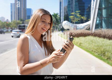 Geschäftsfrau, die Telefongespräche im Finanzdistrikt von Sao Paulo, Brasilien, überprüft Stockfoto