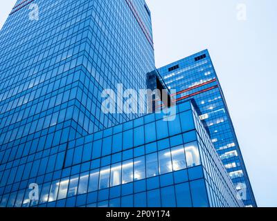 Blick von unten auf Glashochhäuser in blauer Abenddämmerung Stockfoto