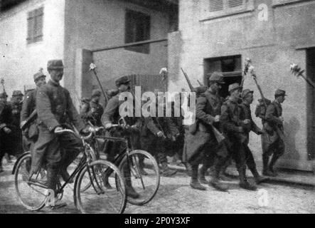 "En Alsace et sur la Frontiere; Le 7 aout, nos fantassins, qui ont fleuri le canon de leurs fusils, et un etat-major de brigade entrent a Thann", 1914. Von „L'Album de la Guerre 1914-1919: Band I“. [L'Illustration, Paris, 1926]. Stockfoto