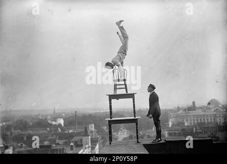 J. Reynolds, Performing Acrobatic and Balancing Acts on High Cornice Above 9. Street, N.W., Washington DC, 1917. "Human Fly" Jammie Reynolds. Stockfoto