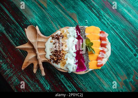 Smoothie-Schüssel in Ananasform, Früchte: Mango, Banane, Kokosnuss, Samen. Gesundes, tropisches Frühstück Stockfoto
