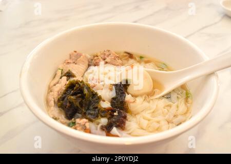 Chinesische Suppe mit Nudeln, Hühnchen und Seetang. Stockfoto