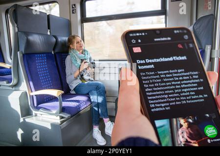 Symbol Bild Deutschlandticket, 49-Euro-Ticket: Nahaufnahme eines Smartphones in einem Regionalzug (komponieren, Modell freigegeben) Stockfoto