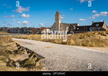 Holländisches Strandresort Katwijk aan Zee, Kirche von der Fußgängerzone aus mit Bänken entlang der Sanddünen Stockfoto