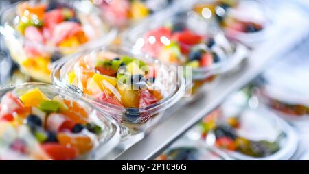 Plastikboxen mit vorverpackten Obstsalaten, in einem handelsüblichen Kühlschrank zum Verkauf aufgemacht Stockfoto