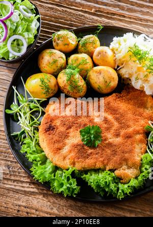 Schweinspanierte Kotelett mit Paniermehl überzogen, serviert mit Kartoffeln und Kohl Stockfoto