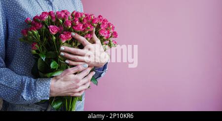 International Women's Day.Konzept des Grußbanners für den internationalen Frauentag am 8. März.Nahaufnahme Frauenhände mit großem Blumenstrauß rosa Rosen o Stockfoto