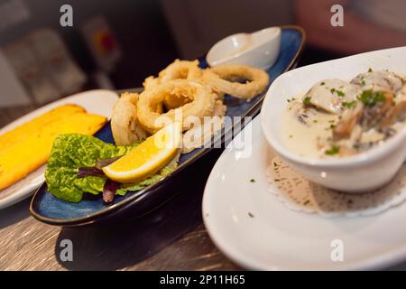 Essen, gekocht, Calamari Frito, gegrillte und frittierte Tintenfischringe, La Tavola Italian Eatery, Southwick, West Sussex, England. Stockfoto