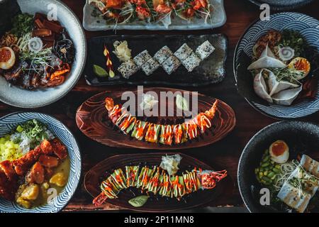 Herzhafte Köstlichkeiten: Ein Top-Down-Blick auf thailändische und asiatische Küche. Die farbenfrohen Zutaten, die aufwendigen Garnierungen und die atemberaubende Präsentation sind ein Fest für t Stockfoto