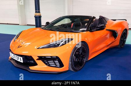 Dreiviertel Vorderansicht einer orangefarbenen Chevrolet Corvette aus dem Jahr 2021, Teil einer Sonderausstellung „70 Years of the Corvette“ auf der London Classic Car Show 2023 Stockfoto