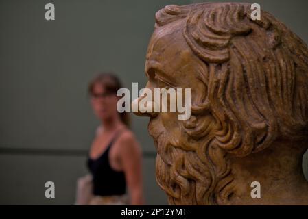 Unbekannte Frau, die das Profil einer Büste von Sokrates in der Galerie degli Uffizien in Florenz, Italien, betrachtet Stockfoto