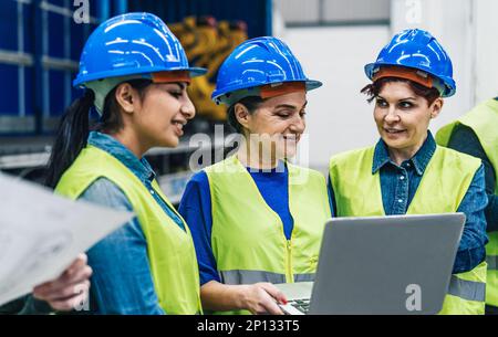 Vielfältige Ingenieurinnen in der Roboterfabrik - Technisches Industriekonzept Stockfoto
