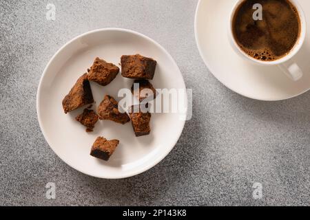 Kithul Jaggery und natürliches Treakel-Süßungsmittel in der Schüssel auf grauem Hintergrund. Blick von oben. Alternativer Zucker und Superfood mit niedrigem glykämischen Index. Kumpel Stockfoto