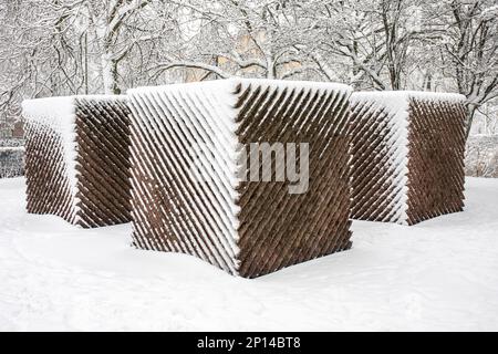 Relander-muistomerkki oder Relande Memorial, ein diagonal genutetes abstraktes Denkmal aus großen Granitwürfeln, das in Helsinki, Finnland, mit Schnee bedeckt ist Stockfoto