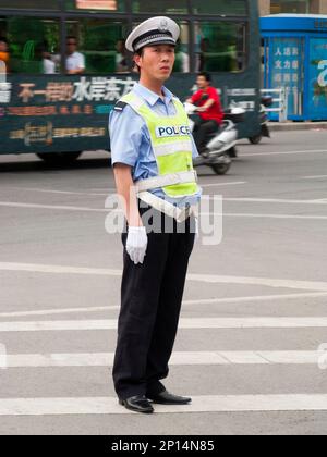 Polizist des Verkehrspolizisten an einer verkehrsreichen Kreuzung in der chinesischen Stadt Xi'an. VR CHINA. China. Führen und Anweisen von vorbeifahrenden Fahrzeugen. (125) Stockfoto