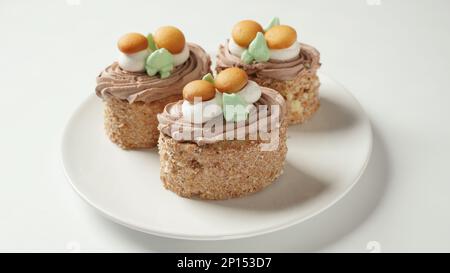 Mit cremefarbenen Blumen und Pilzen dekorierte Kekskuchen Stockfoto