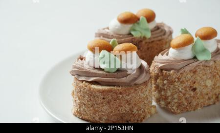 Mit cremefarbenen Blumen und Pilzen dekorierte Kekskuchen Stockfoto