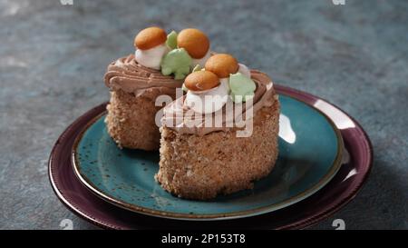 Mit cremefarbenen Blumen und Pilzen dekorierte Kekskuchen Stockfoto