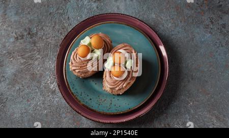 Mit cremefarbenen Blumen und Pilzen dekorierte Kekskuchen Stockfoto