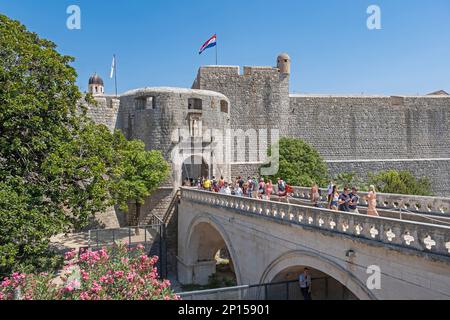 Stadtmauern und Touristen betreten das Pile Gate, Haupteingang zur Altstadt, historisches Stadtzentrum von Dubrovnik, süddddalmatisches, Kroatien Stockfoto