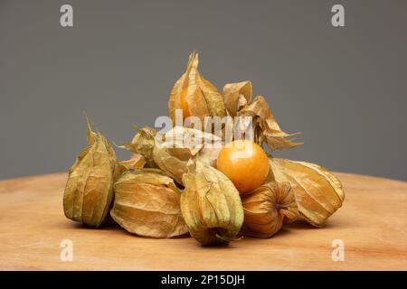 Ein Haufen reifer Physalis-Früchte auf einem Holztisch. Nahaufnahme des Studios, Vorderansicht. Stockfoto