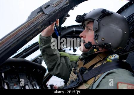 LUFTWAFFENSTÜTZPUNKT DER KÜSTENWACHE KODIAK, Alaska -- Alaska Air National Guard Major Tyler Seibold, 210. Rettungsschwadron HH-60G Pave Hawk Pilot, führt am 12. Januar 2023 Vorflugkontrollen durch, während gemeinsamer Ausbildung mit dem Maritime Security Response Team West der Küstenwache. Der HH-60 ist die einzige spezielle, rotierende Kampfplattform des Verteidigungsministeriums. Stockfoto