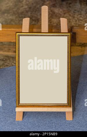 Golden Portrait Frame at Wooden Easel Holder Copy Space Stockfoto
