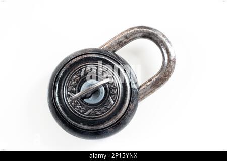 Korrodiertes altes Schloss im Vintage-Stil mit wunderschöner Metalldekoration isoliert auf Weiß mit Schlüsselloch im Inneren. Stockfoto