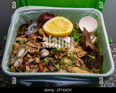 Haushaltsabfallbehälter mit Gemüsereste in einer Plastiktüte Nahaufnahme in der Küche. Stockfoto