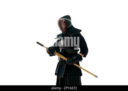 Porträt eines Mannes, eines professionellen Kendo-Athleten in Uniform, der mit einem Shinai-Schwert vor weißem Studiohintergrund posiert Stockfoto