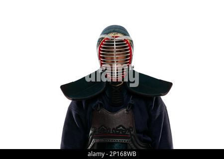 Vorderansicht. Porträt eines Mannes, eines professionellen Kendo-Athleten in Uniform, der mit einem Shinai-Schwert vor weißem Studiohintergrund posiert Stockfoto