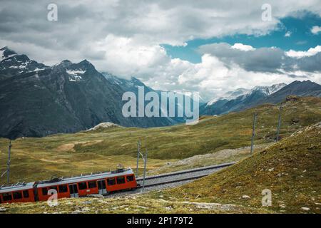 Eisenbahn und roter Zug im Gornergrat-Gebirge. Zermatt, Schweizer Alpen. Abenteuer in der Schweiz. Stockfoto