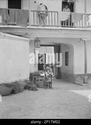 Reiseansichten von Europa, zwischen 1904 und 1938. Junge Frau im Hof, mit Gemüsekörben und Waagen. Stockfoto