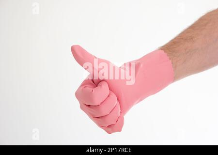 Pinkfarbener Latex-Reinigungshandschuh auf weißer männlicher Hand mit Daumen-hoch-Geste isoliert auf weißem Hintergrund. Stockfoto