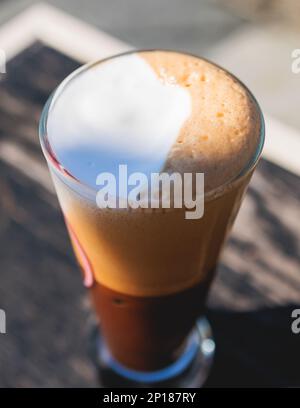 Eine Tasse griechischer eiskalter Kaffee auf einem Tisch, Frappe, ein Glas Freddo, Fredo Capuchino serviert in der Taverne des Straßencafés, auf der Insel Korfu, Kerkyra, Griechenland, griechisch Stockfoto