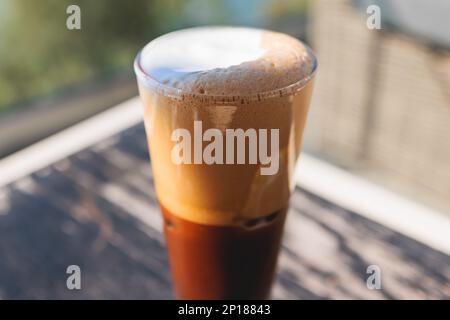 Eine Tasse griechischer eiskalter Kaffee auf einem Tisch, Frappe, ein Glas Freddo, Fredo Capuchino serviert in der Taverne des Straßencafés, auf der Insel Korfu, Kerkyra, Griechenland, griechisch Stockfoto