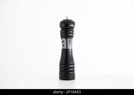 Schwarze Holzmühle mit Pfeffermühle, Studio, abgeschossen auf Weiß. Stockfoto