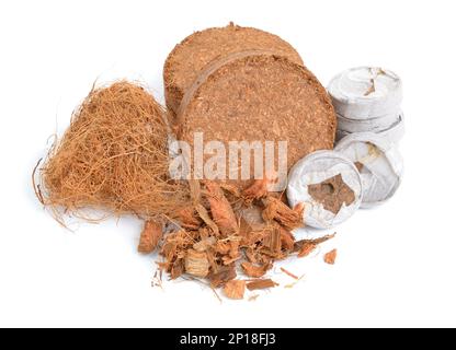 Kokosnuss-Coir-Substrat. Pressbriketts mit Tisch und Faser. Isoliert auf weißem Hintergrund. Stockfoto